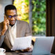 Front view of smiling young accountant looking over documents while working in a cafe